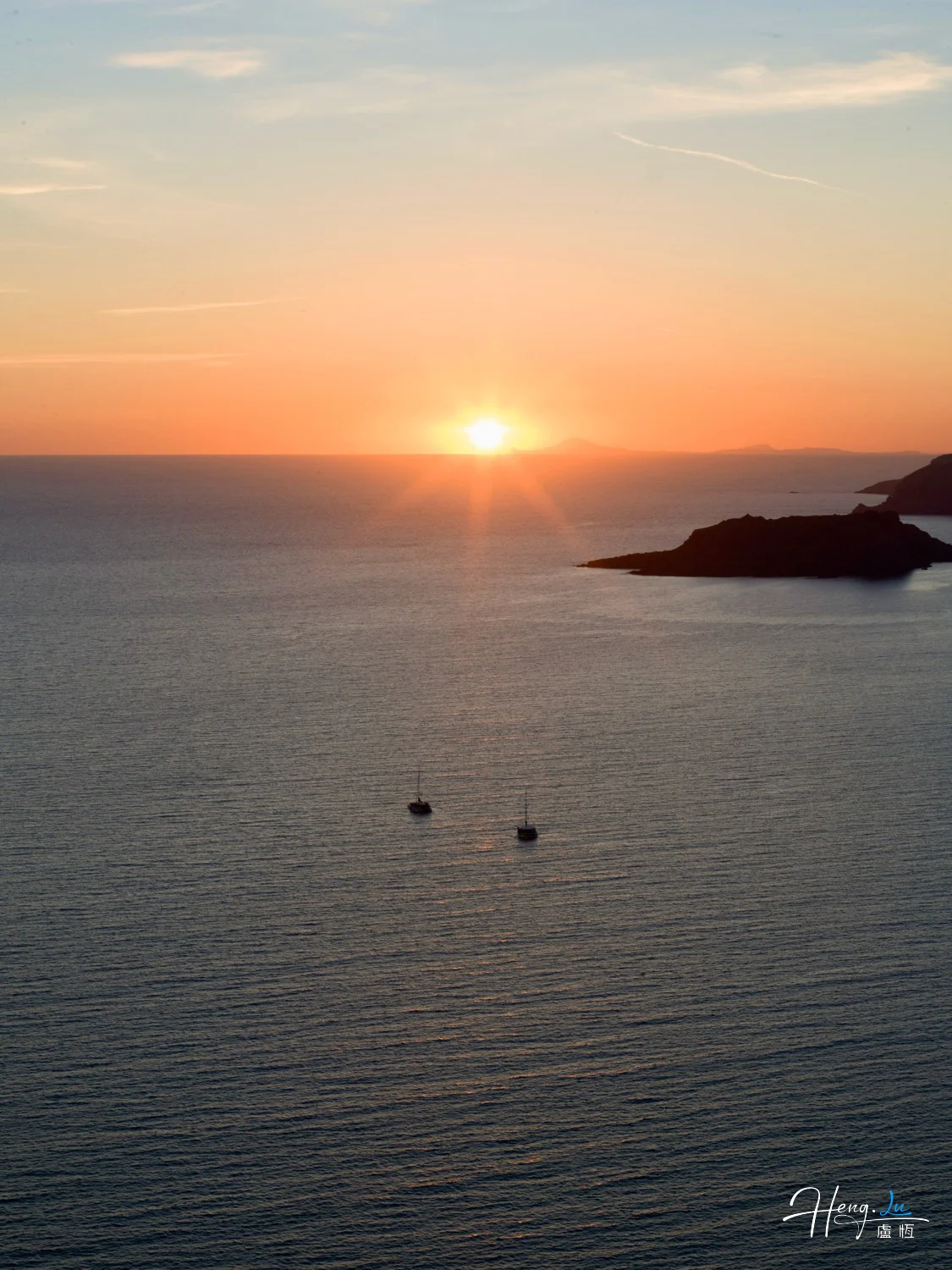 Sunset-over-sea-with-two-sailboats
