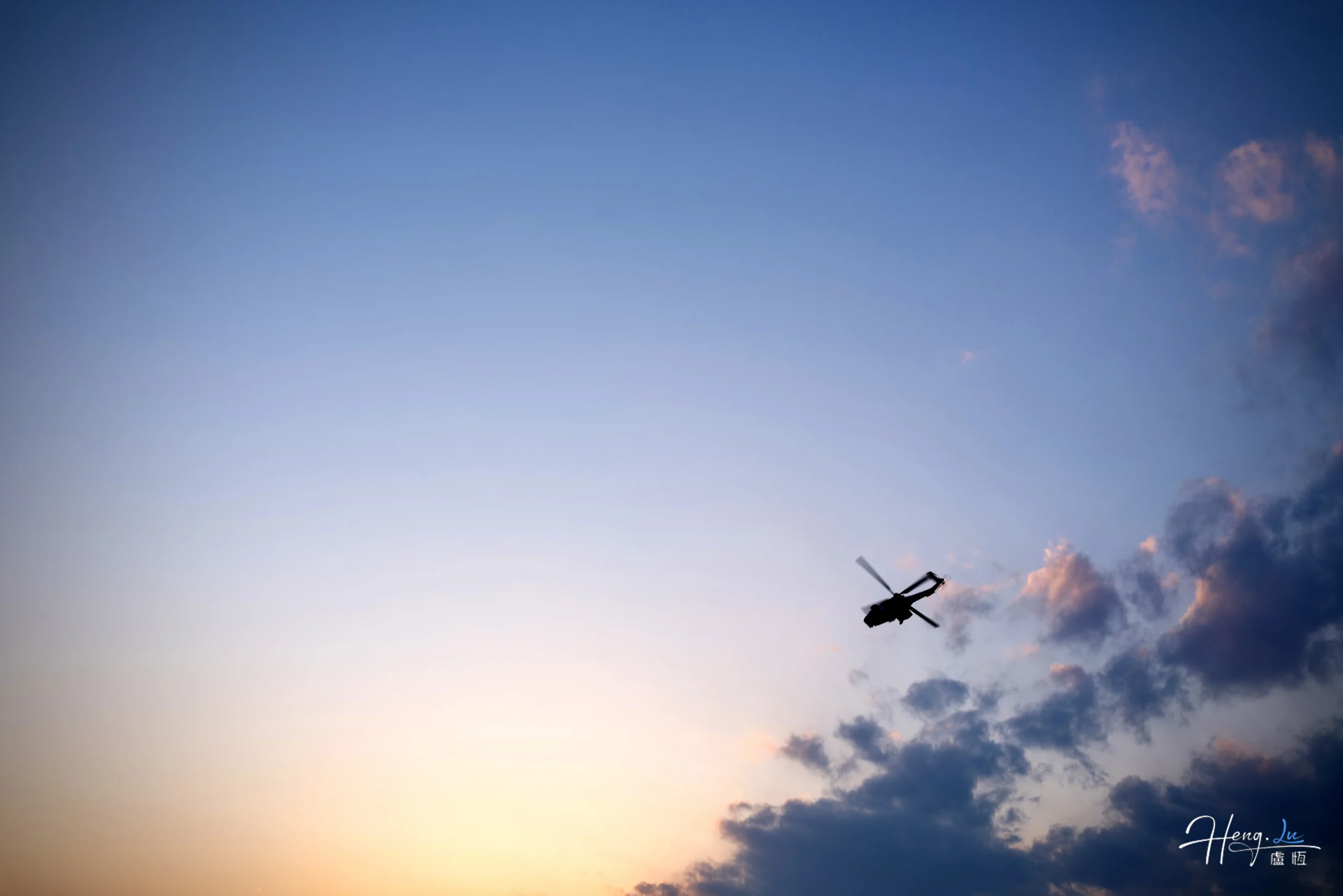 helicopter-flying-through-sunset-sky