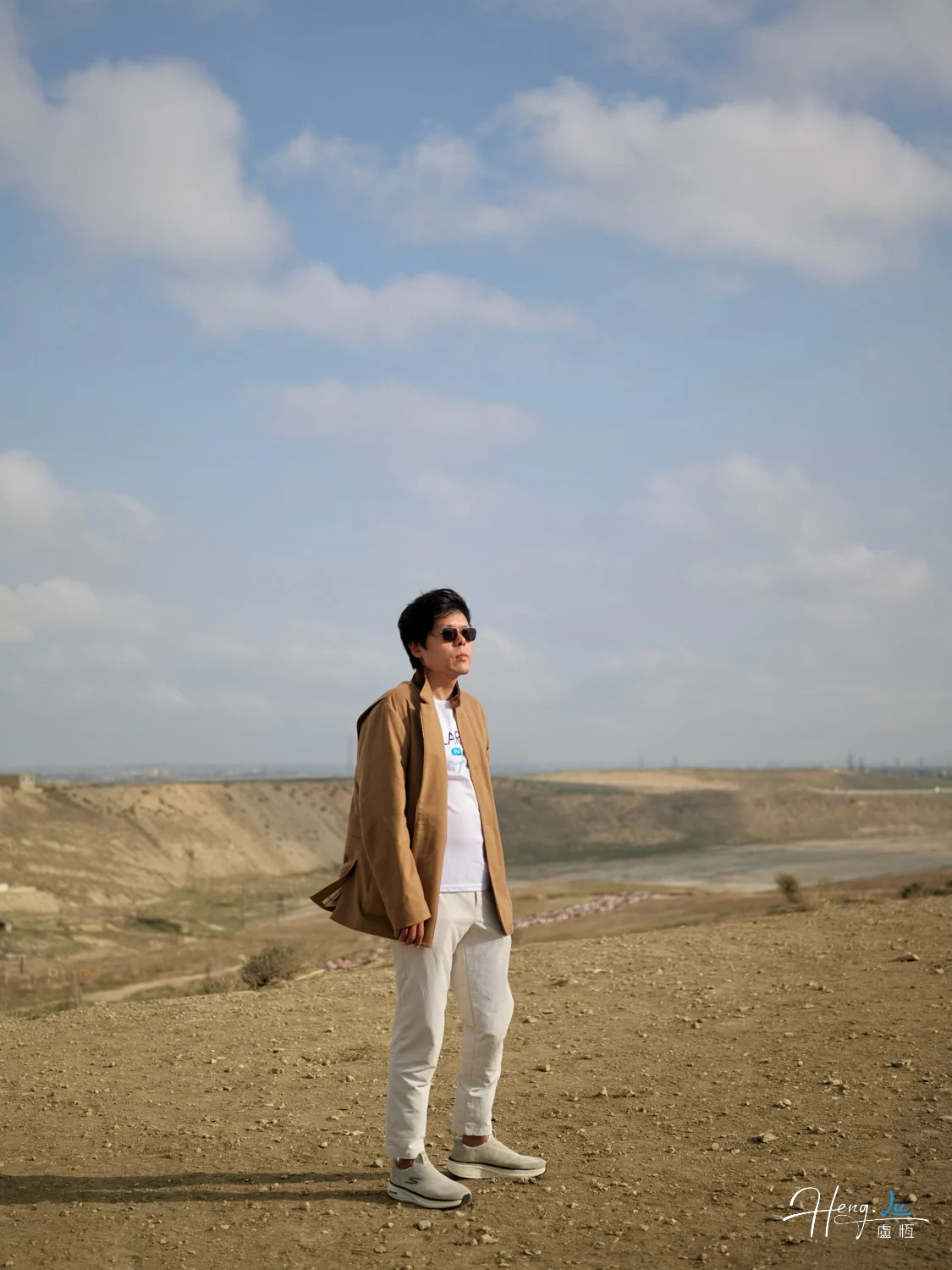 Luheng-standing-on-windy-hilltop-under-clouds
