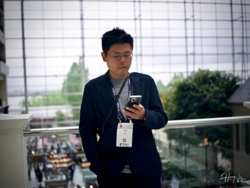 Luheng-checking-phone-in-modern-atrium