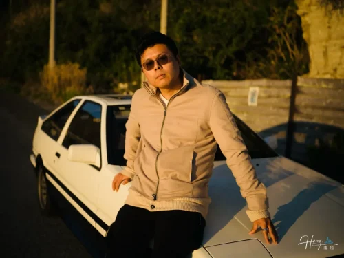 Luheng-leaning-on-white-car-under-sunset-light