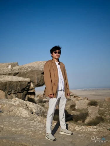 Luheng-standing-on-sunlit-rocky-plateau